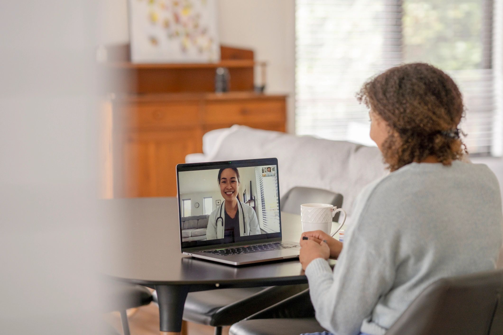 Person joining a telehealth video call on a laptop