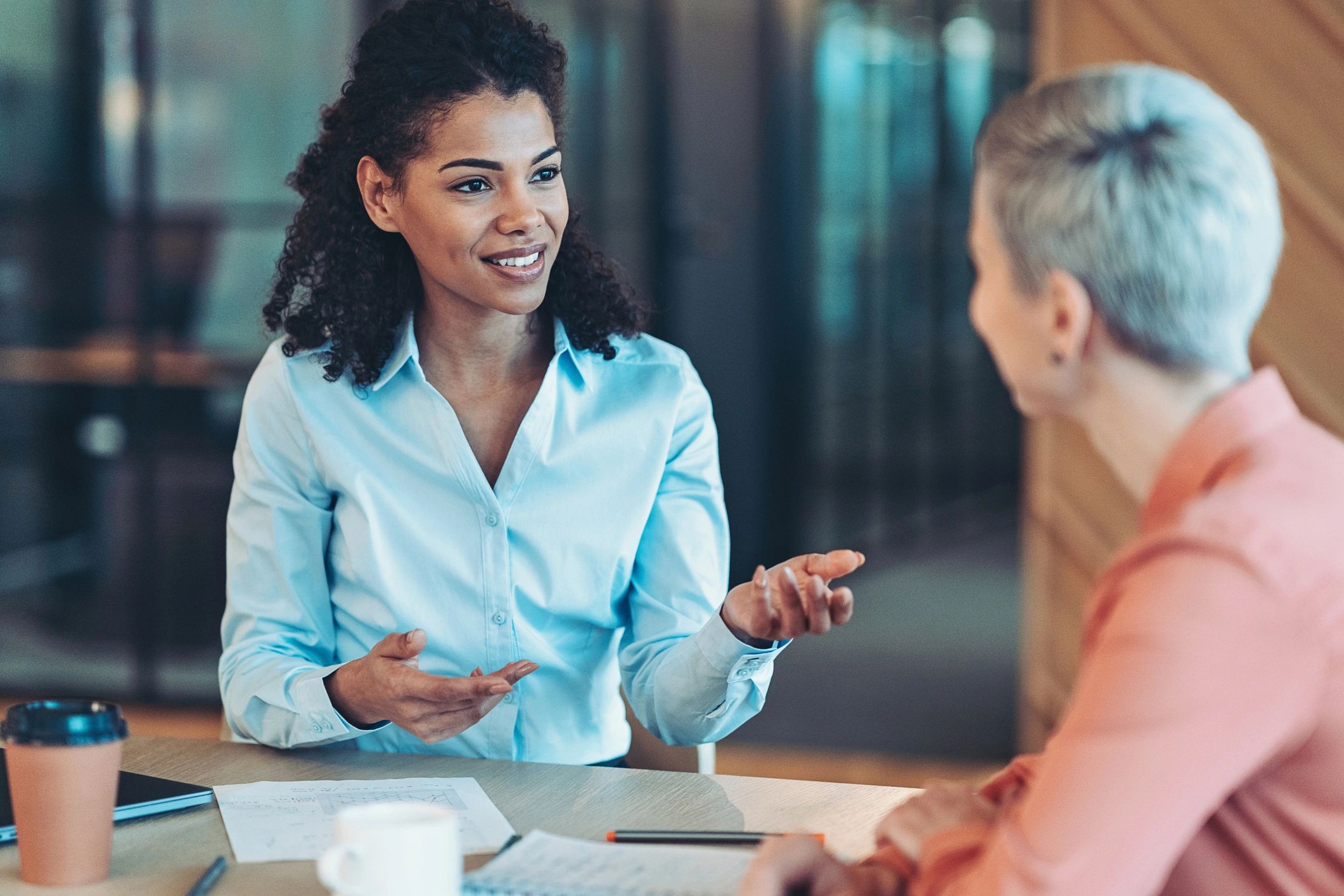 Two professionals in a supportive coaching conversation