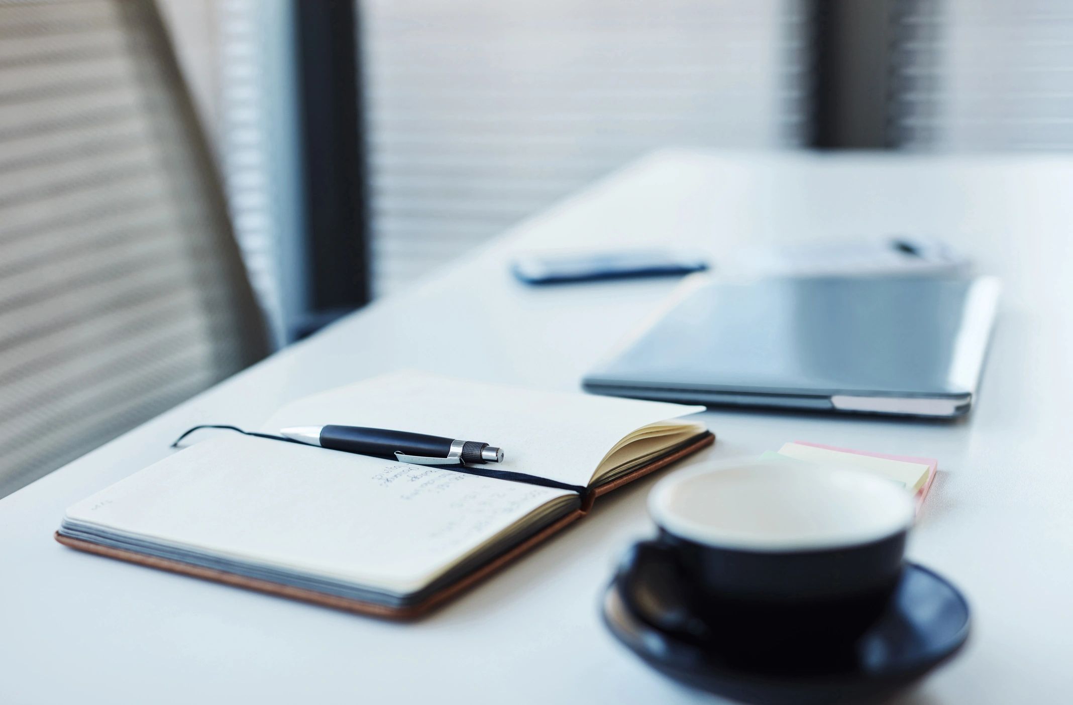 Office desk with notebook and laptop representing recordkeeping and communication