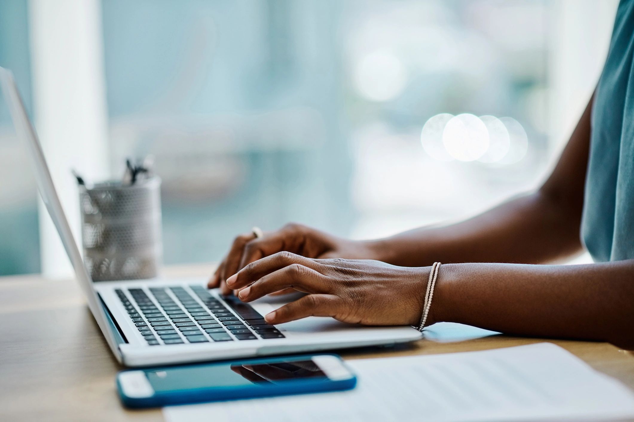 Hands typing on a laptop while working on a resume
