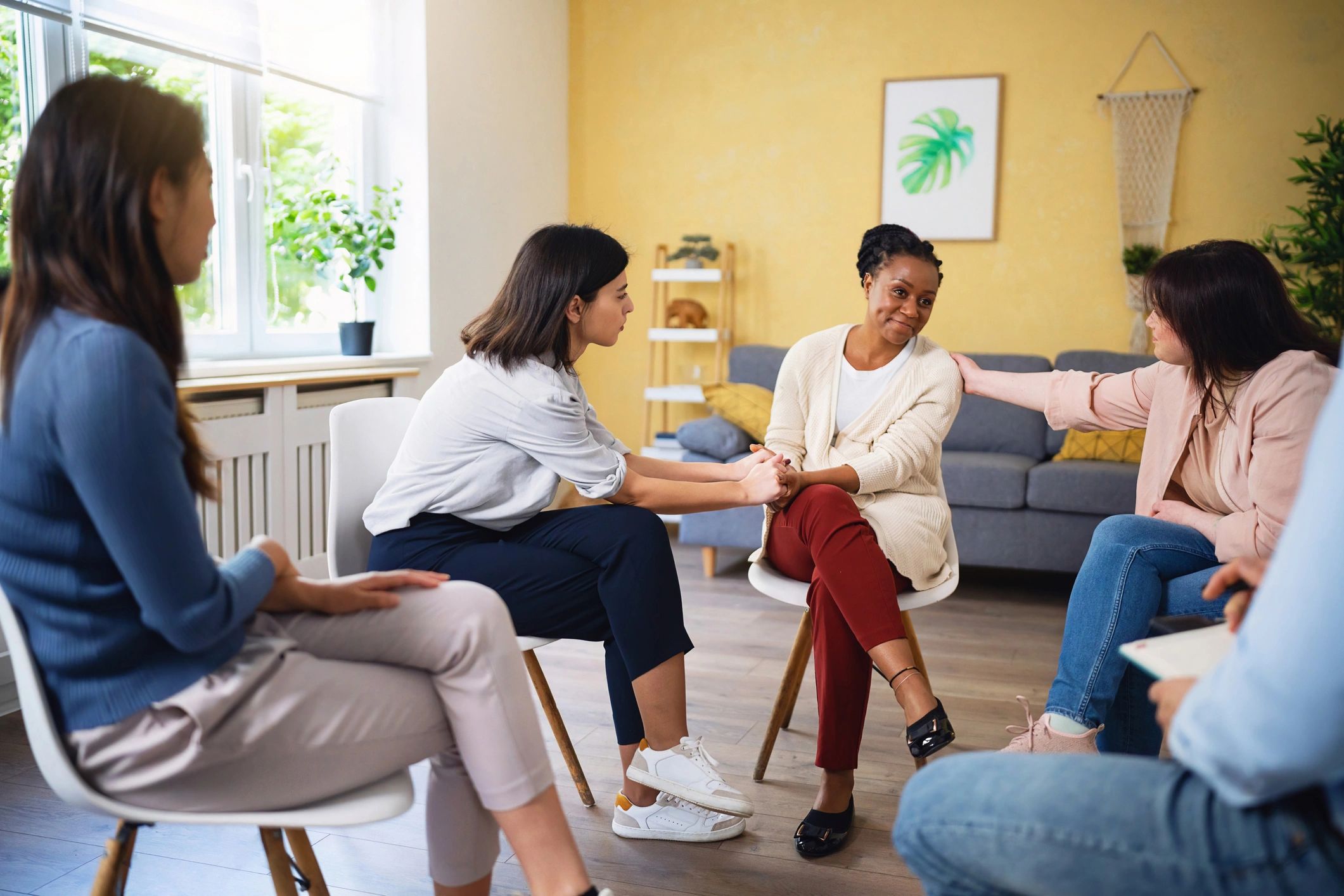 People consoling a woman during a group therapy session
